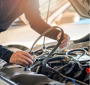 Mécanicien automobile remplaçant la courroie de transmission dans un moteur de voiture ouvert à Saint-Gilles dans le Gard 30